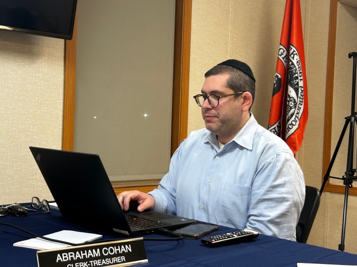 Village Clerk/ Treasurer Abraham Cohan detailing garbage truck financing