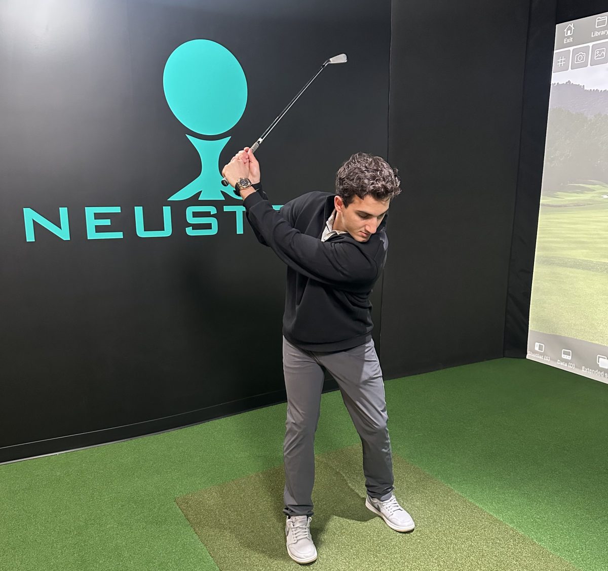 Former pro Mark Roder practices his swing in a Neustryk simulation bay.