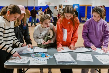Students explored various stations which offered opportunities to investigate air pressure principles through balloon experiments, aerodynamics by testing paper airplanes and other interactive science activities.