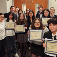 Manhasset students holding their certificates for literary magazine recognition