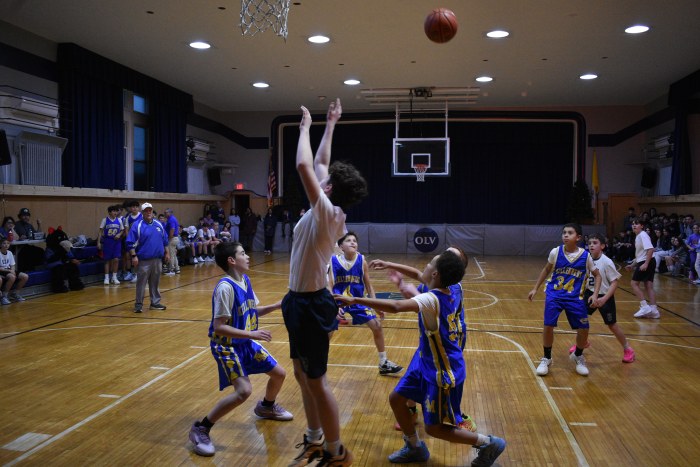A student jumps for a rebound at the boys' basketball teams first ever game, also the program's inaugural contest.