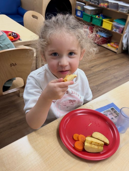 Port Washington Children's Center student enjoying pizza.