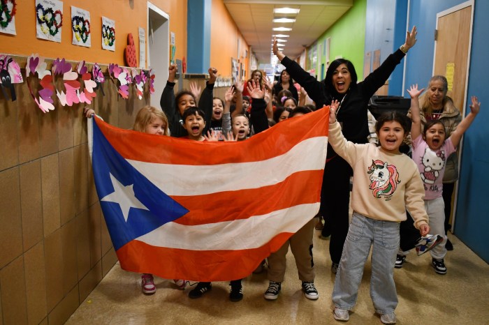 Students carried the flag of Puerto Rico in an Olympic parade.
