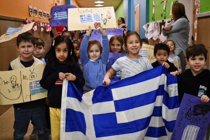 Students carried the flag of Greece in an Olympic parade.