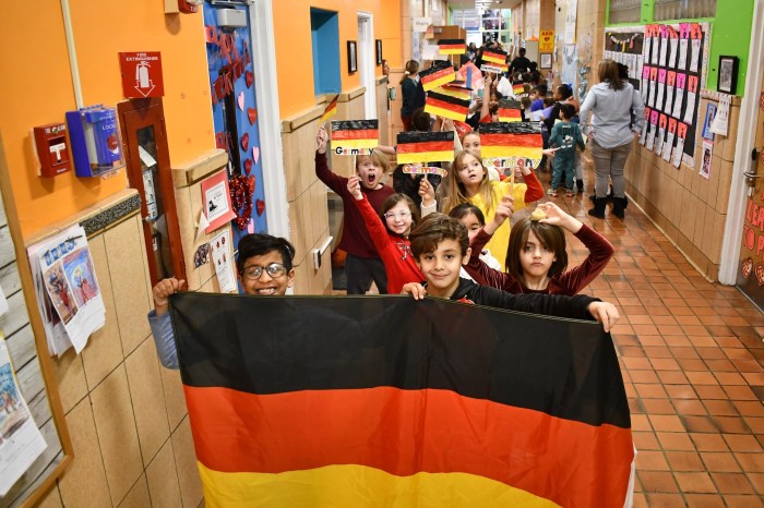 Students carried the flag of Germany in an Olympic parade.