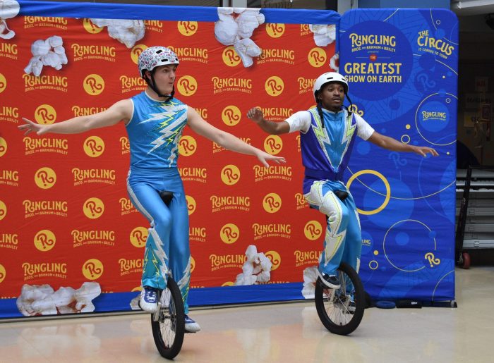 Zeke Pranis-Ricci (L.) and Hassani Muya (R.) performed on unicycles for the children.