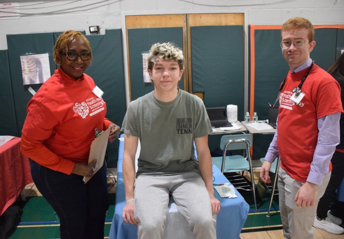 2: Seaford High School junior Jackson Pignataro prepared for his EKG with Dr. Sandra Nurse and medical student Kieran Mannion.