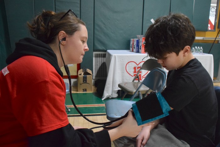 Nursing student Emma Kurtz checked the blood pressure of ninth grader Mason DeVerna before going in for his heart screening.