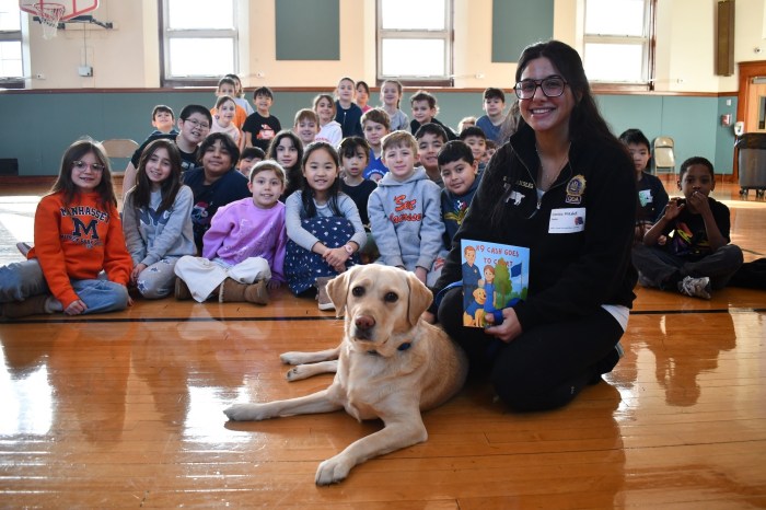 NYPD Detective Dionisia Mikalef with Kimi, a specialized therapy dog who provides comfort to crime victims and witnesses, reads to third graders at Munsey Park.