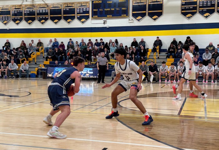Jericho sophomore guard Deven Mudgil D's up Bethpage senior Chase Solliday.