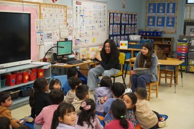High school students read books aloud in Spanish.