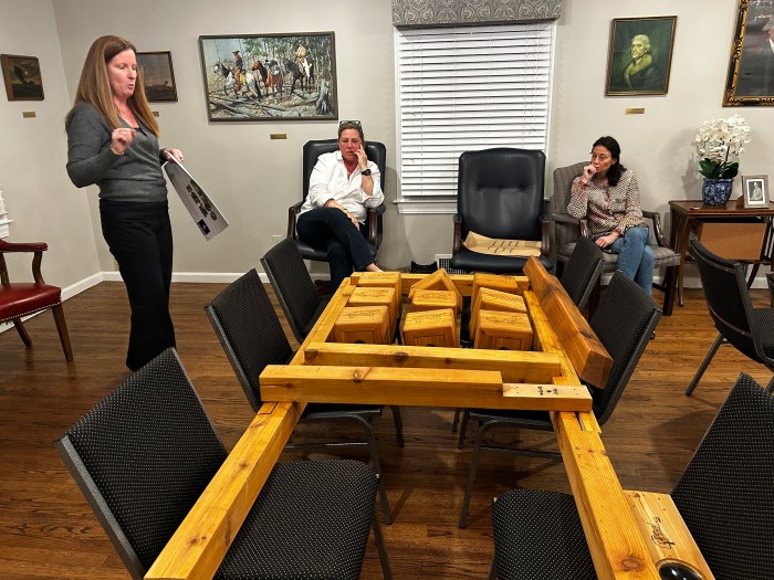 Munsey Park Women's Club member Colleen Sharkey (L.) presenting the tic-tac-toe board and magnifying station to the village.