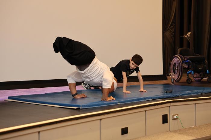 Rohan Murphy selected a second grade student from John Philip Sousa Elementary to show the crowd how to do a push-up.
