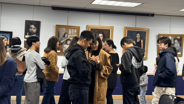 Attendees filled the gallery at the opening of the 'Between Us' exhibit at Jericho Library.