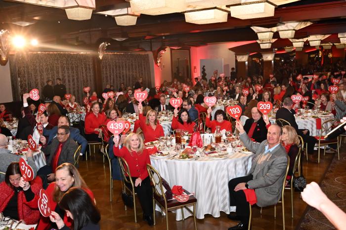 Volunteers and leaders raise their paddles in support of women’s heart health at the 2026 Long Island Go Red for Women Celebration.