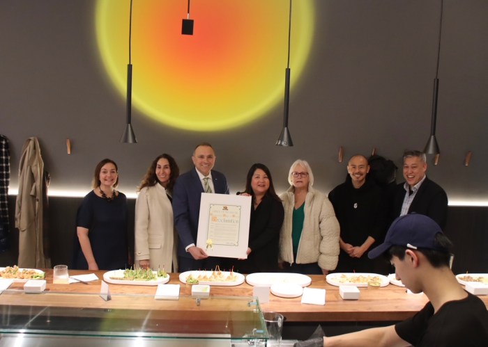 Mineola Mayor Paul Pereira (Center L.) gives business owner Mimi Chi (Center R.) a certificate.